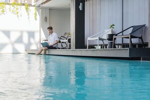 室外游泳池，池畔遮阳伞，日光浴躺椅