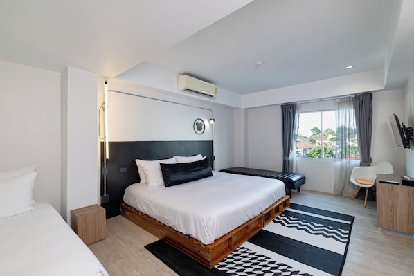 A modern hotel room with a large bed, bedside table, and a view of the outdoors.