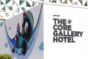 Ein großes Wandbild eines Affen in einer Hängematte, und der Text "The Core Gallery Hotel".
