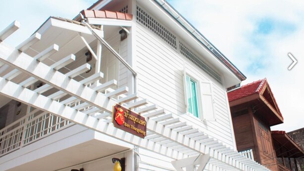 Un edificio blanco con un balcón y un letrero que dice 'Doi Suthep Hotel'.