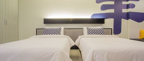 Una habitación de hotel con dos camas, una decoración grande en la pared y un televisor sobre las camas.