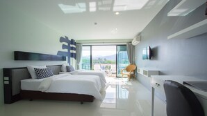 Una habitación de hotel moderna con una cama grande, un escritorio y una televisión.
