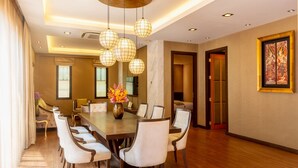 A spacious dining area with a long table, multiple chairs, and pendant lighting. - Chiva Bangkok Hotel (Bangkok)