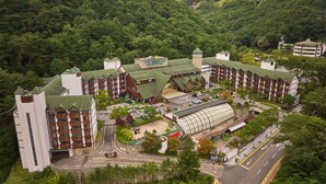 Ein Resort mit mehreren Gebäuden, einer großen Überdachung und einer Straße, die zum Eingang führt.