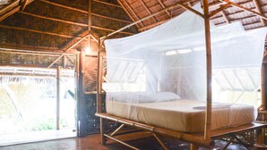 A bamboo-framed bed with a mosquito net, a wooden floor, and a thatched roof. - Forra Diving Resort - Pattaya Beach - Koh Lipe (Koh Lipe)