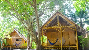 A traditional bamboo structure with a hammock and a thatched roof, surrounded by lush greenery. - Forra Diving Resort - Pattaya Beach - Koh Lipe (Koh Lipe)