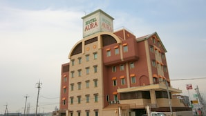 Un hotel de varios pisos con un cartel llamativo que dice "Hotel Aura".