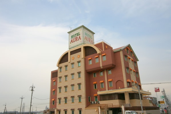 A multi-story hotel with a prominent sign reading "Hotel Aura."