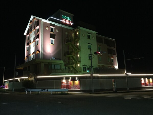 Un hotel de varios pisos con un cartel llamativo que dice "HOTEL AURA".