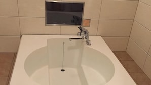 Una bañera rectangular con un solo grifo y desagüe.