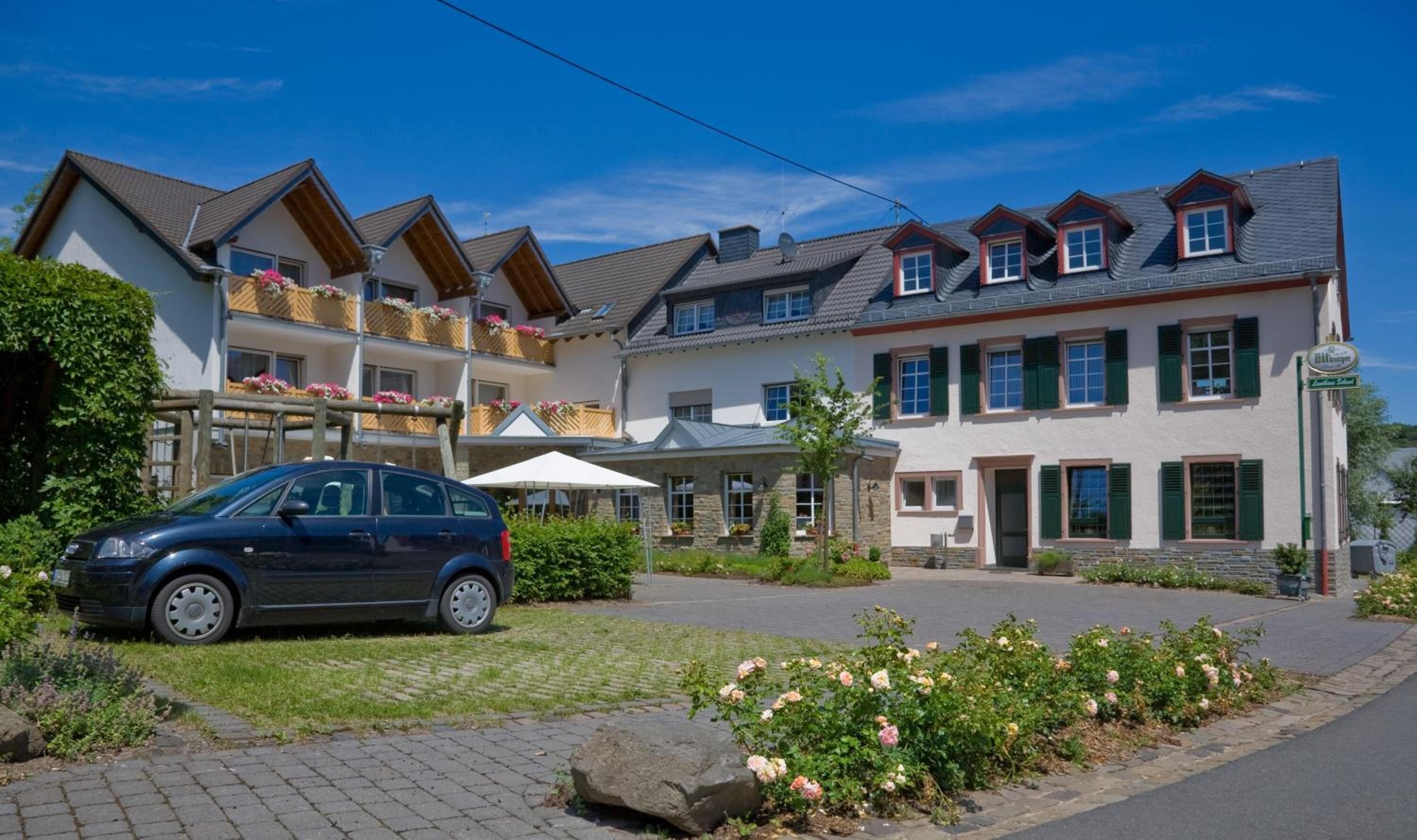 A two-story building with a car parked in front.