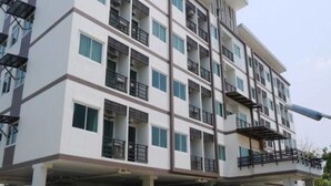 Un immeuble résidentiel à plusieurs étages, doté de balcons, de grandes fenêtres et d’un toit plat.