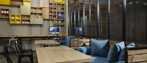 Un interior moderno con una mesa de madera, un sofá azul y estantes con diversos objetos.