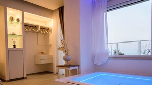 Un baño moderno con bañera, tocador y estante decorado con objetos.