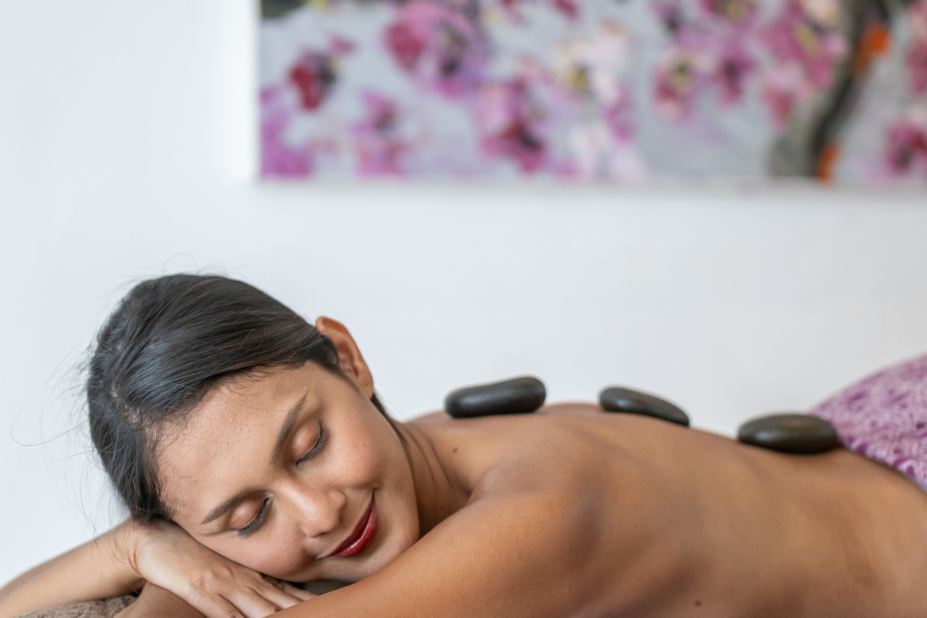 Een persoon ontvangt een rugmassage met stenen.