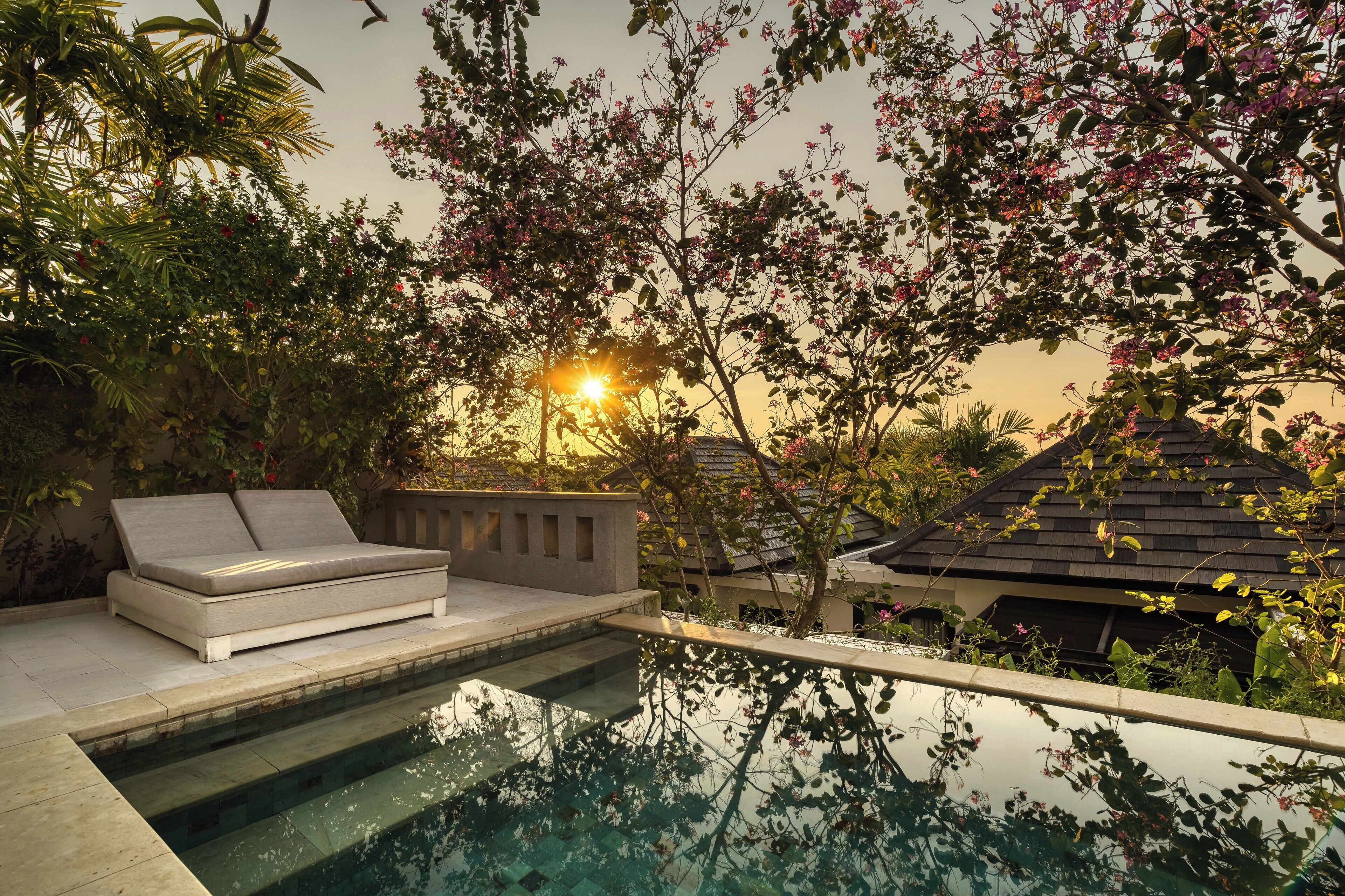 Ein Poolbereich mit einer Sitzecke und einem Haus im Hintergrund.