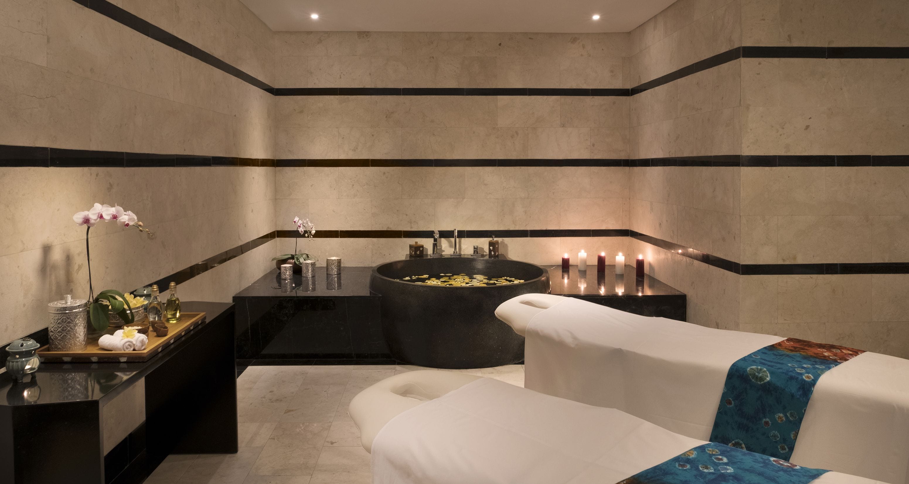 Un baño moderno con una bañera grande, un tocador con espejo y una bandeja con artículos de aseo.