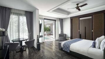 Een moderne hotelkamer met een groot bed, een ronde tafel met stoelen, een plafondventilator en uitzicht op het buiten.