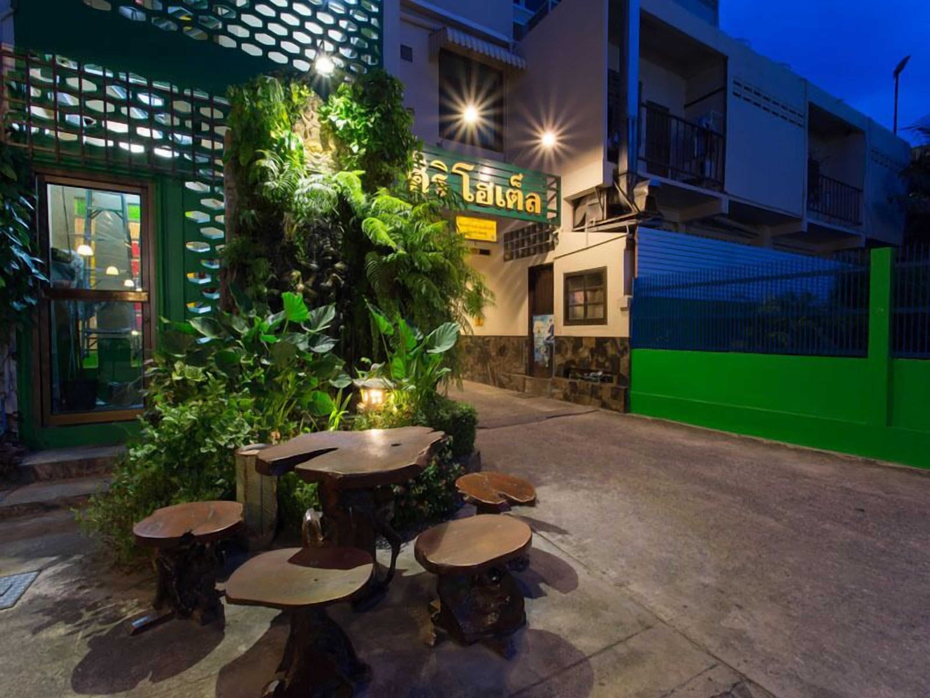 A restaurant with outdoor seating and a green facade.