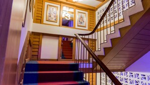 A staircase with a wooden handrail and a patterned railing. - Siri Hotel (Nakhon Ratchasima)