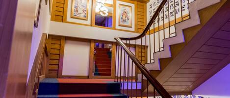 Un escalier avec une main courante en bois et une rampe ornée de motifs.