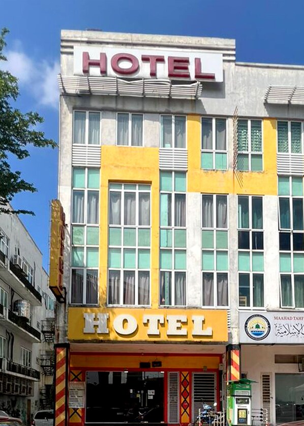 A hotel with a prominent 'HOTEL' sign, large windows, and a yellow facade. - Kota Damansara Boutique Hotel (Petaling Jaya)