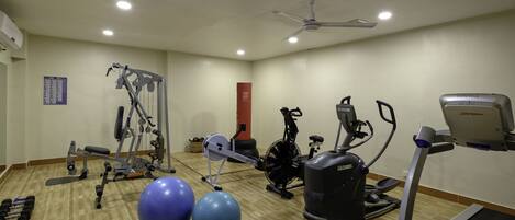 A gym with exercise equipment, two large exercise balls, and a treadmill.
