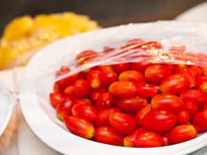 Un plato blanco lleno de tomates cherry.