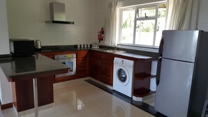 Eine moderne Küche mit Einbauofen, Waschmaschine und Kühlschrank.