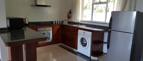 Una cocina moderna con horno empotrado, lavadora y refrigerador.