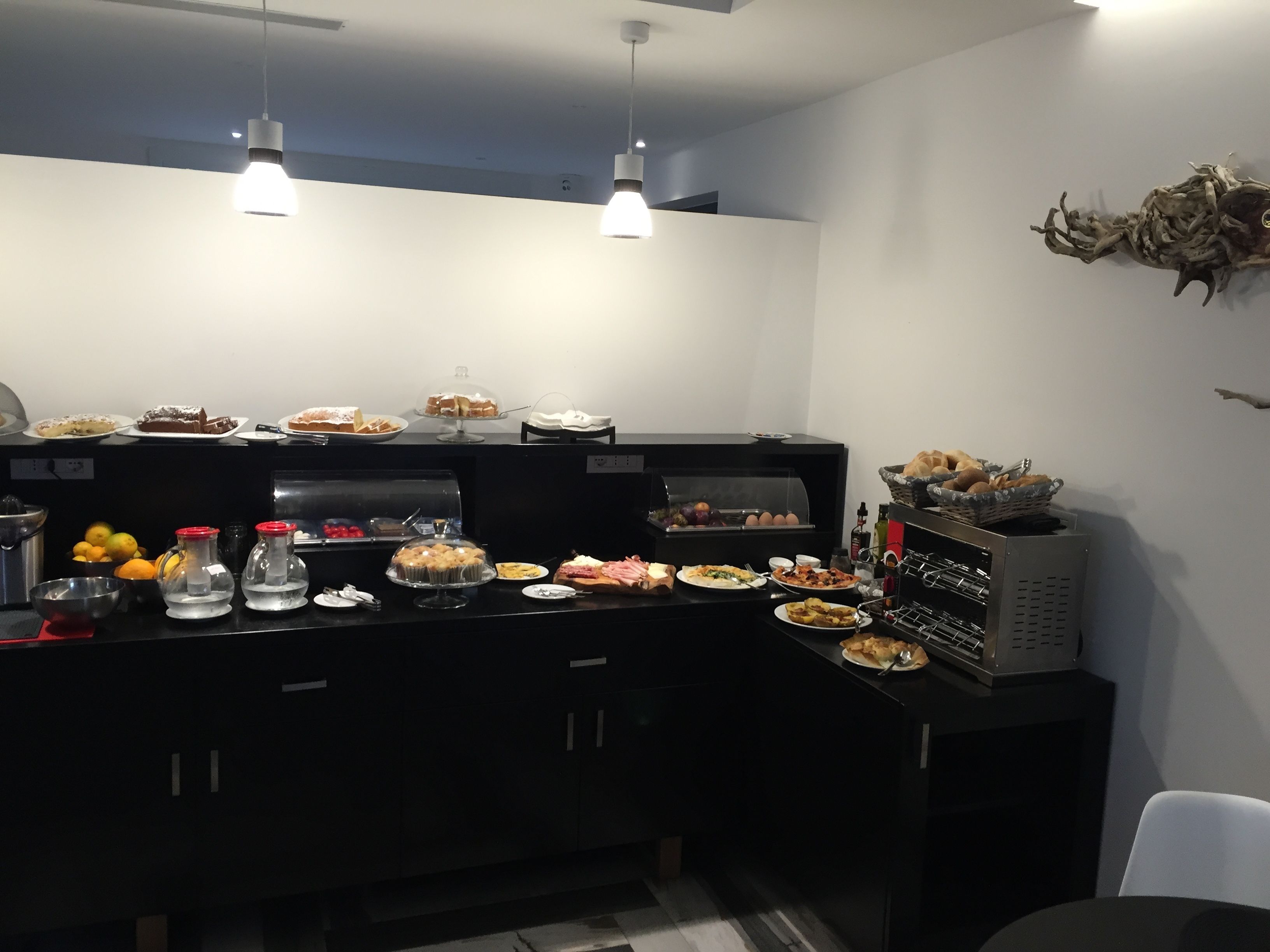 Ein reichhaltiges Buffet mit verschiedenen Speisen, einer Kaffeemaschine und einem Weinkühler.