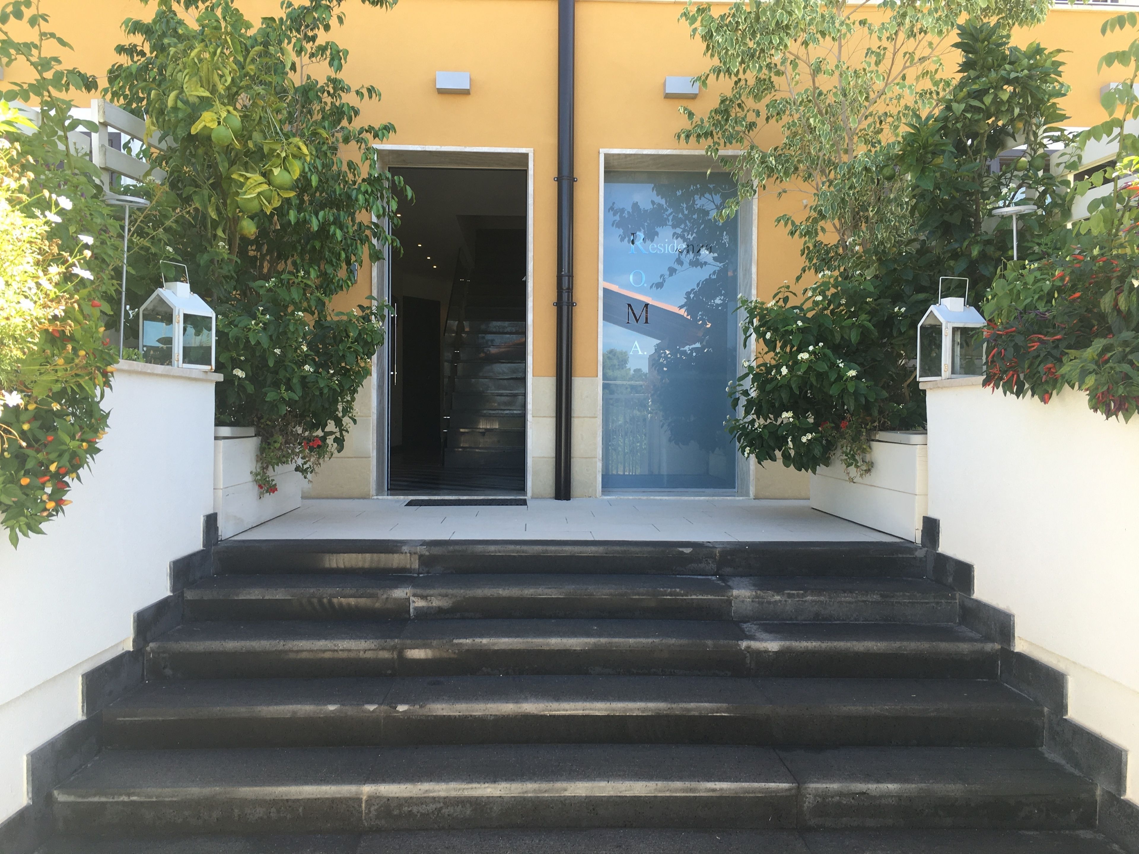 Una entrada de edificio con una escalera que conduce a una puerta.