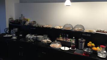 A buffet setup with various food items and condiments.