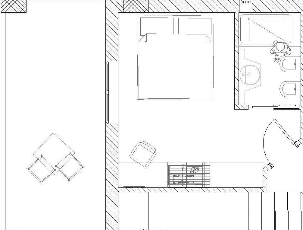 A floor plan of a hotel room with a bed, a bathroom with a bathtub, a shower, and a sink. There is also a small seating area with a table and chairs.