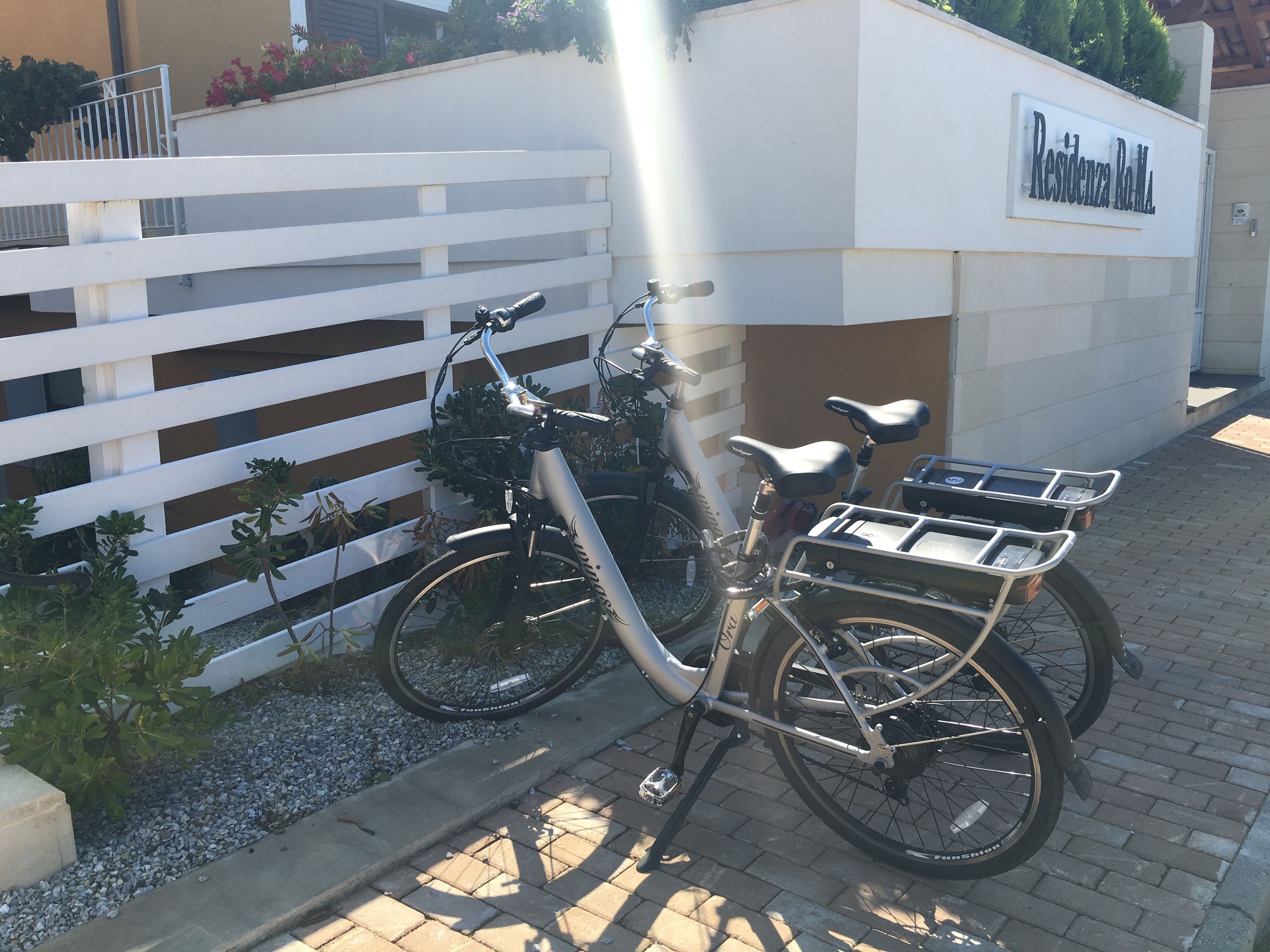 Una bicicleta estacionada al lado de un edificio con un cartel que dice "Residencia RoMaL".