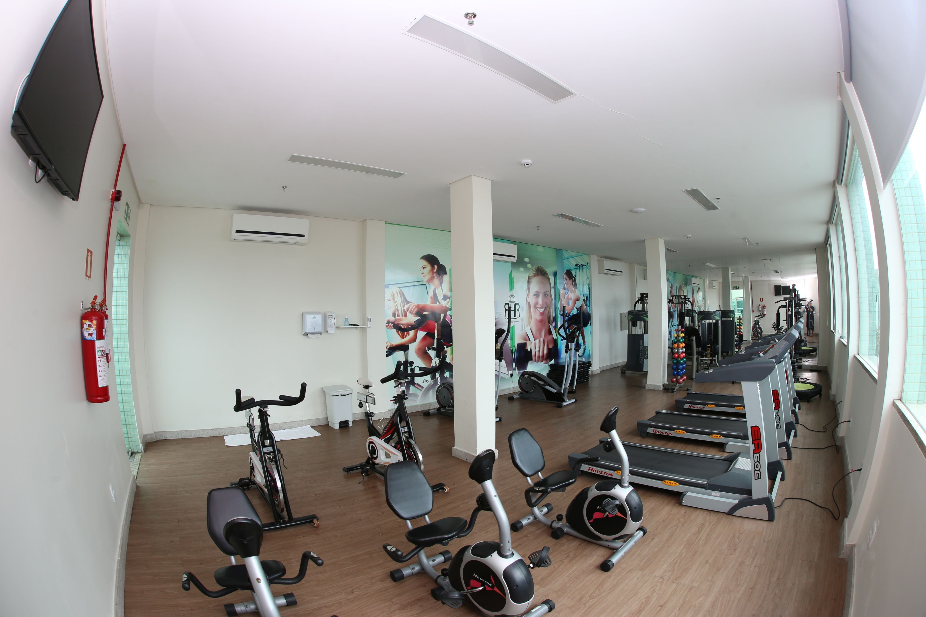 A gym with stationary bikes, treadmills, and exercise balls.