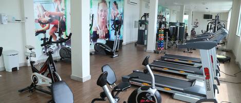 A gym with stationary bikes, treadmills, and weight machines.