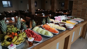 Um buffet com diversas frutas, legumes e pratos.