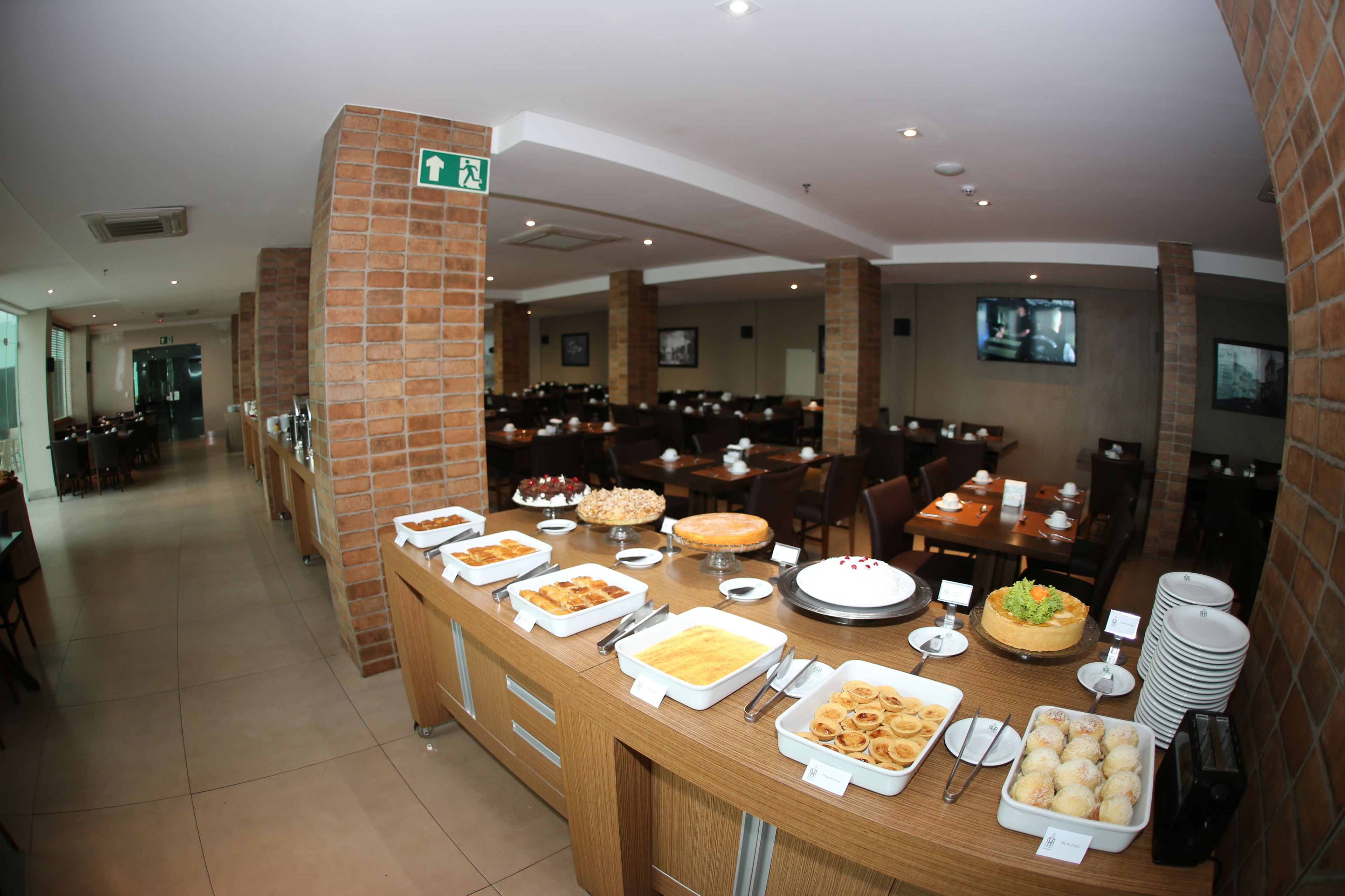 A buffet area with various food items and a seating area in the background.
