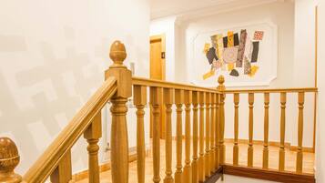 A wooden staircase with a patterned wall and a framed artwork above it.