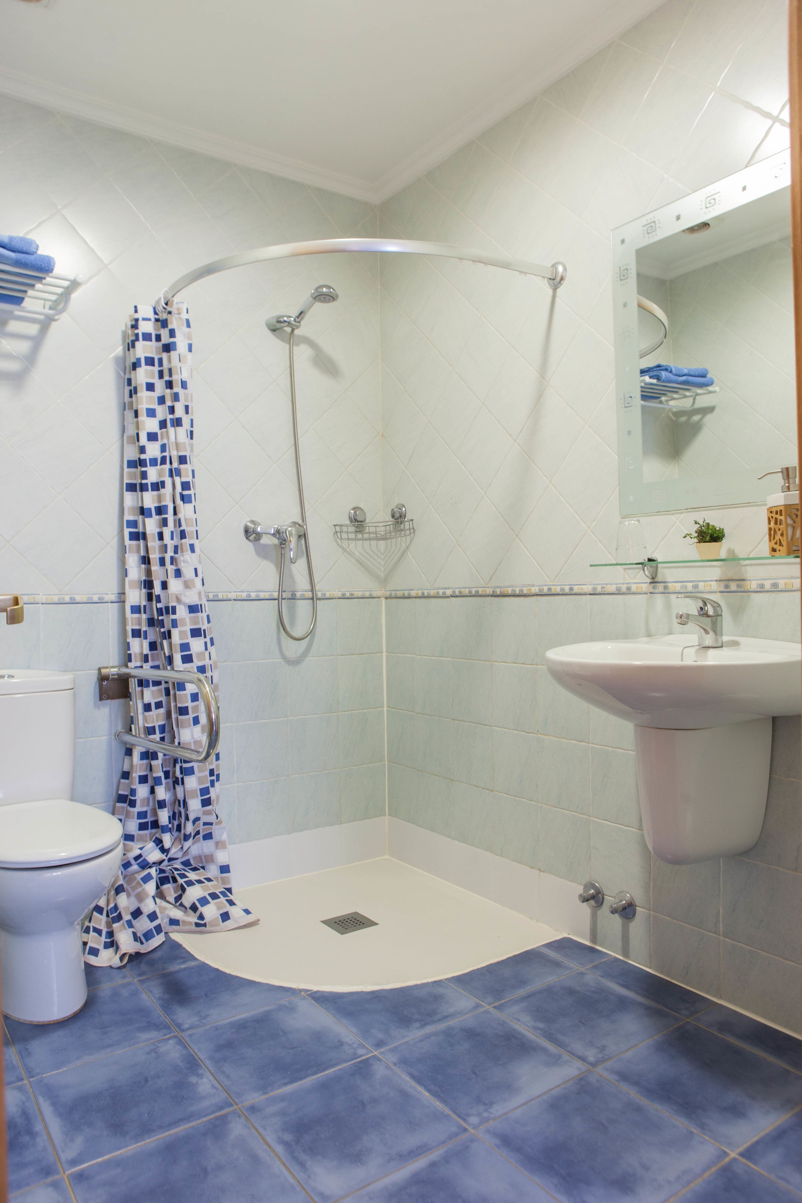 A bathroom with a shower, toilet, and sink.