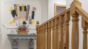 Una escalera con balaustres de madera y suelo de baldosas.