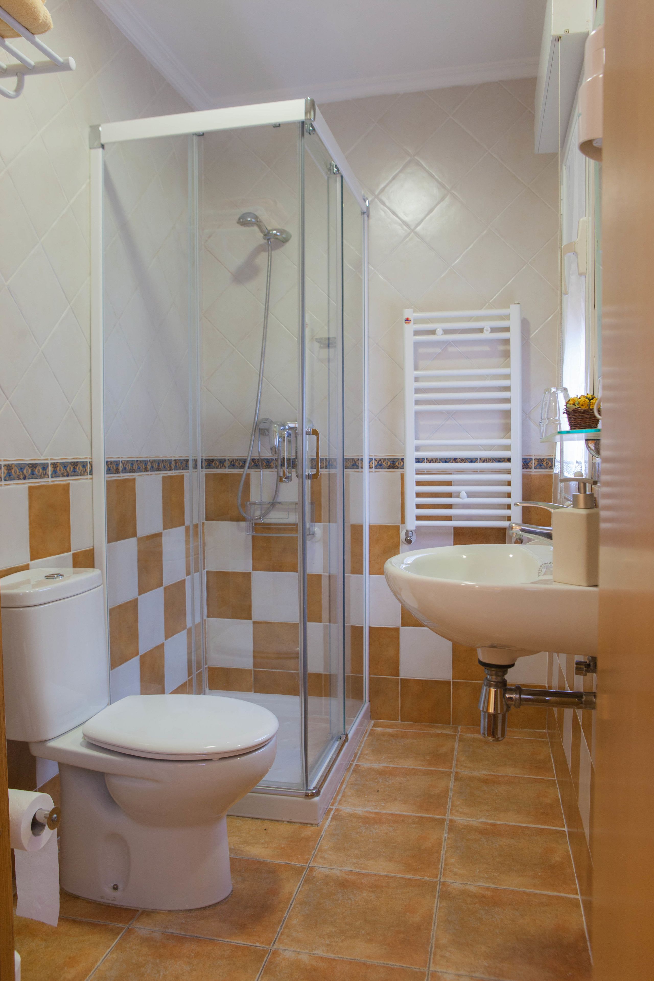 Ein Badezimmer mit einer Duschkabine, einer Toilette und einem Waschbecken.