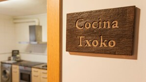 Un letrero de madera con el texto 'Cocina Txoko' colgado en una pared.
