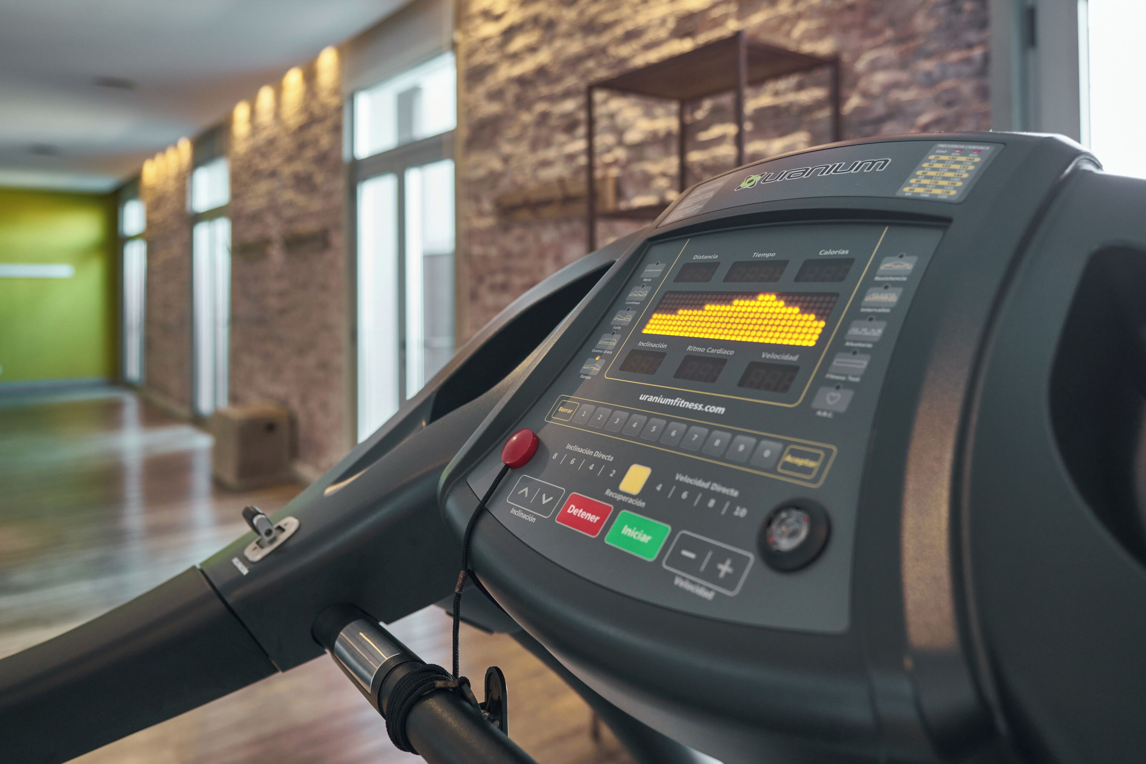 Ein Laufband mit digitaler Anzeige, Bedienelementen und einem daran angeschlossenen Kabel.