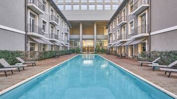 Una piscina al aire libre, sillones reclinables de piscina