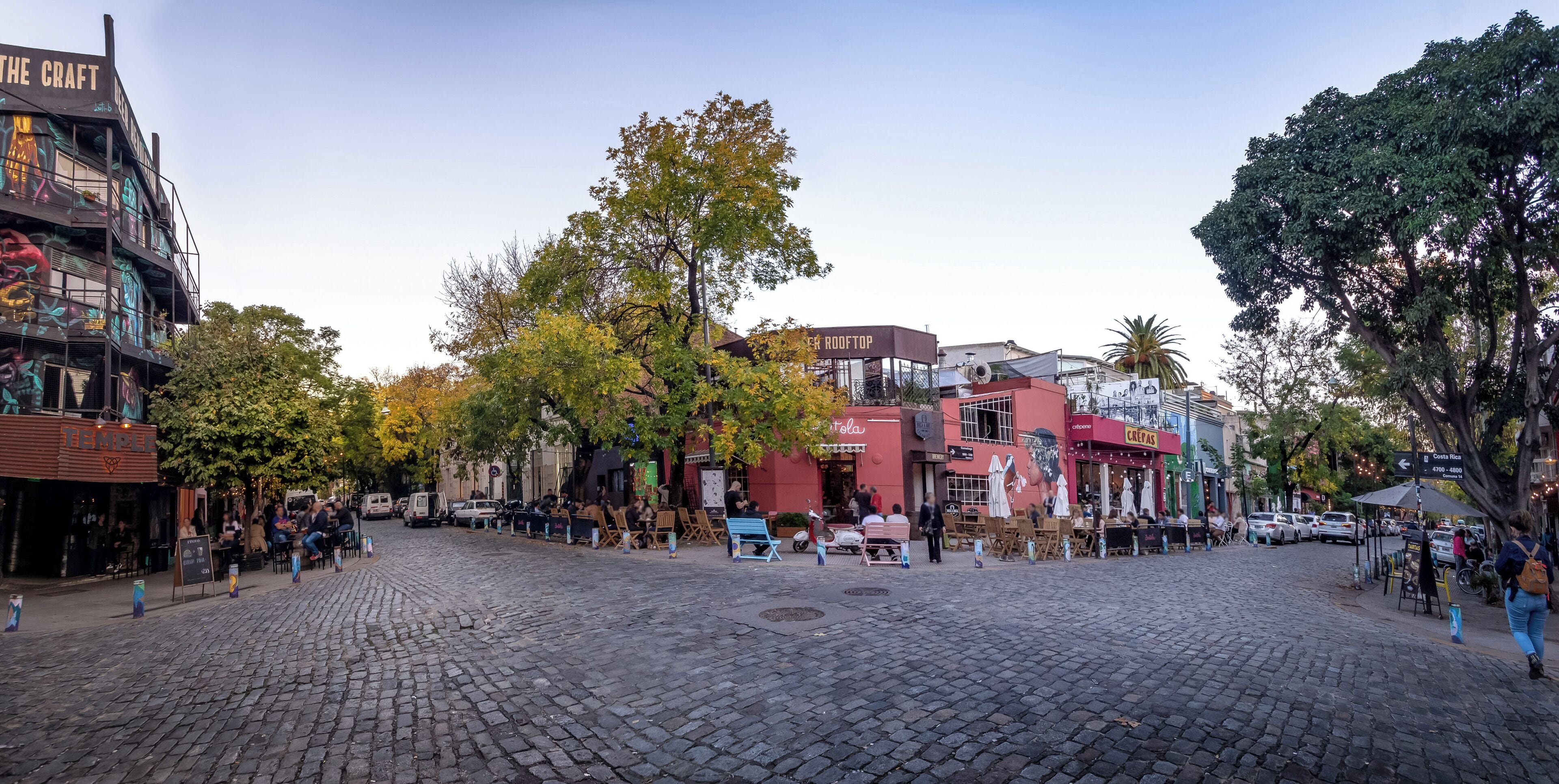 A cobblestone square with outdoor seating, cafes, and a mix of commercial buildings.