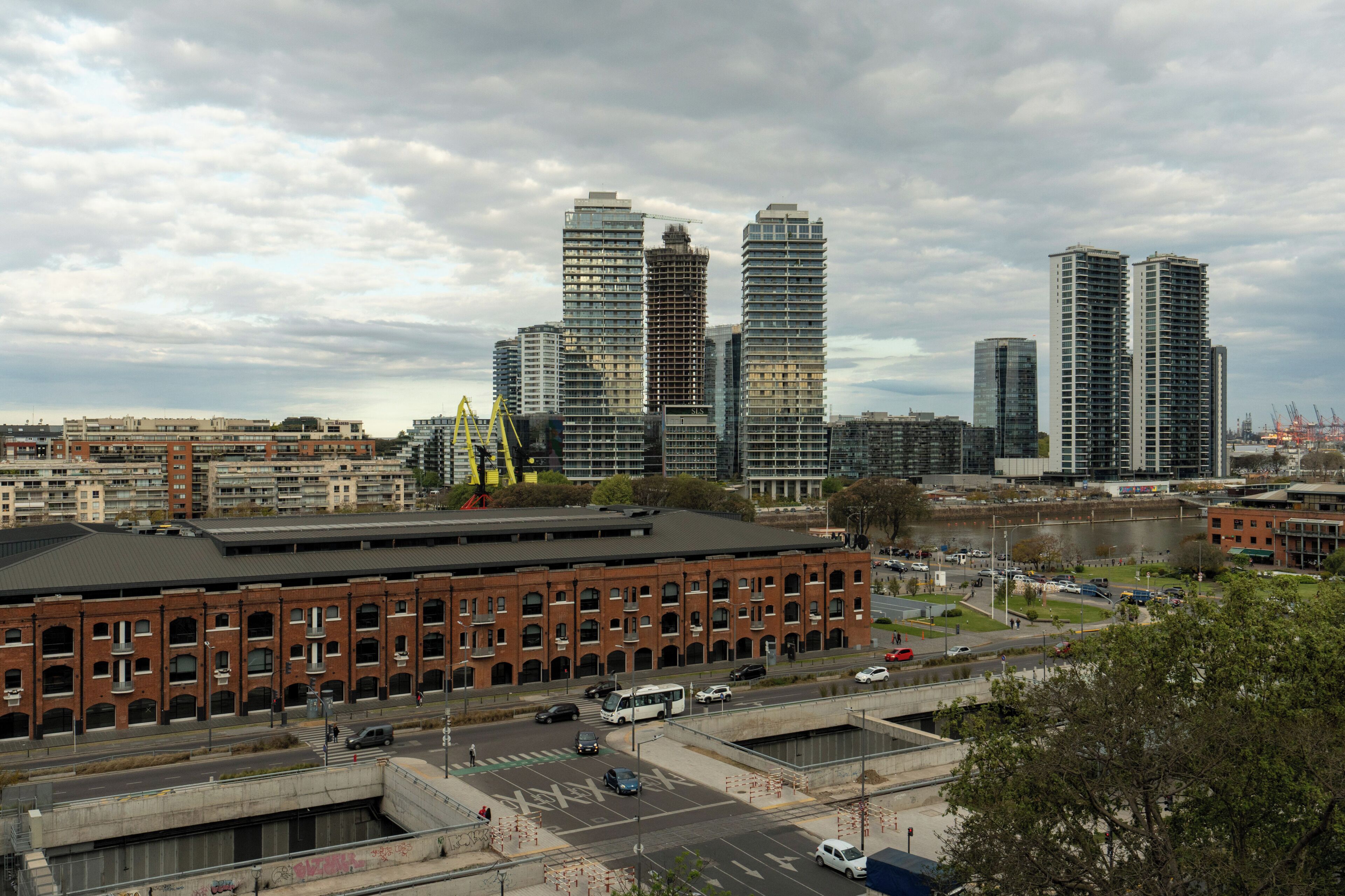 A cityscape with high-rise buildings, a large brick building, and a river.