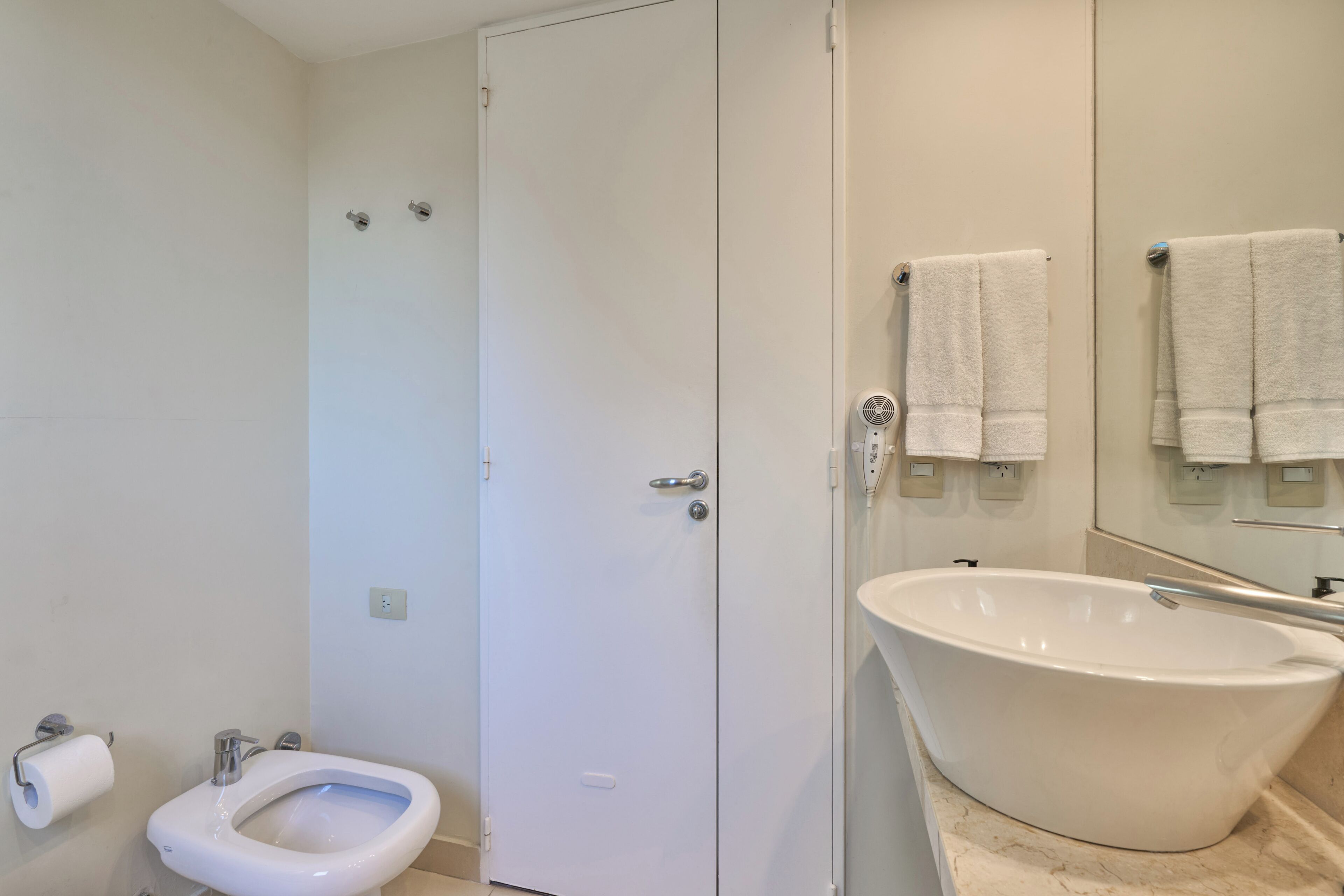 Un baño con inodoro, bidé y bañera independiente.