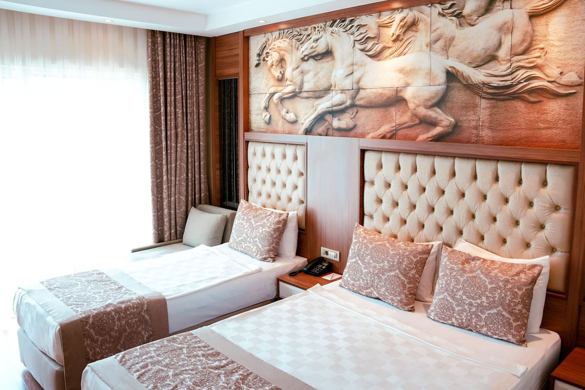 A hotel room with two beds, a large mural of horses, and a modern design.